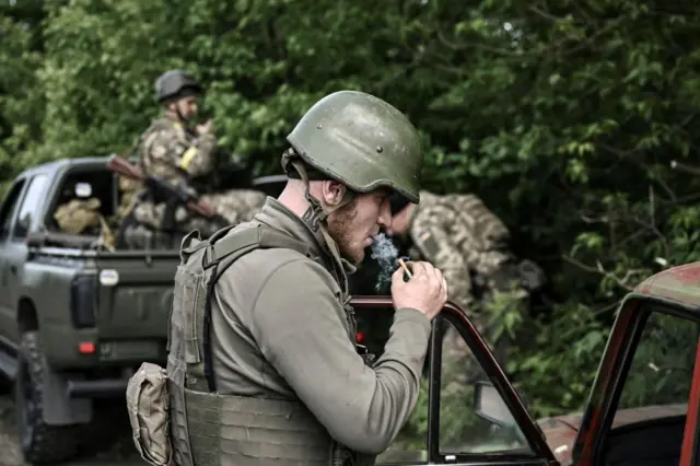 Ukrainian servicemen take some rest prior to move toward the frontline at a checkpoint near the city of Lysychansk in the eastern Ukranian region of Donbas,