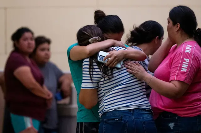 People console each other at the Ssgt Willie de Leon Civic Center