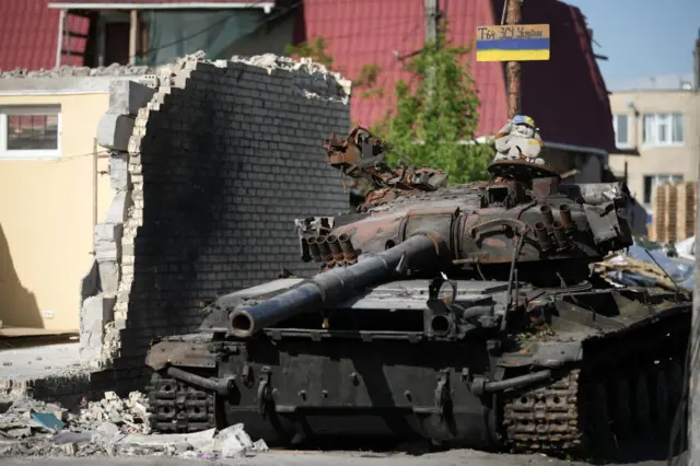 children's cuddly toy sits on top of a destroyed Russian main battle tank, next to war damaged homes, on May 24, 2022 in Hostomel, Ukraine.