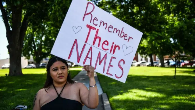 An Uvalde resident stands vigil outside the school