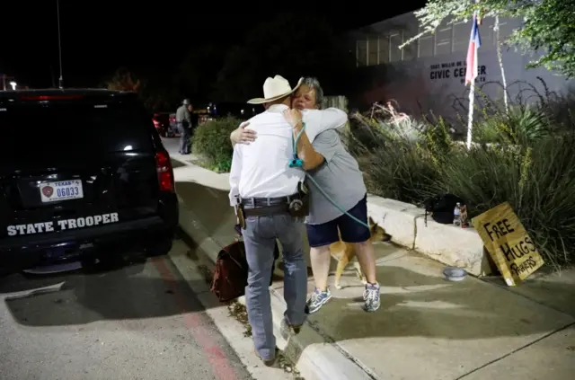 A woman offers free hugs and prayers