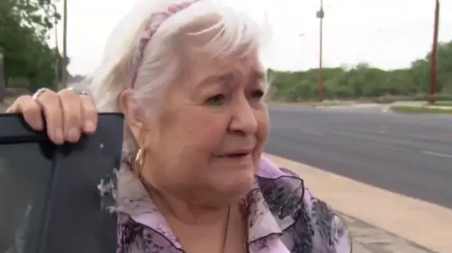 Uvalde resident standing by her car