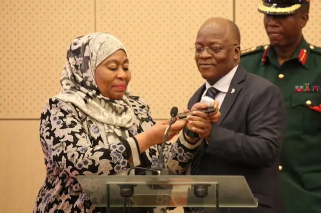 Tanzania President Samia Hassan (L) and her predecessor John Magufuli
