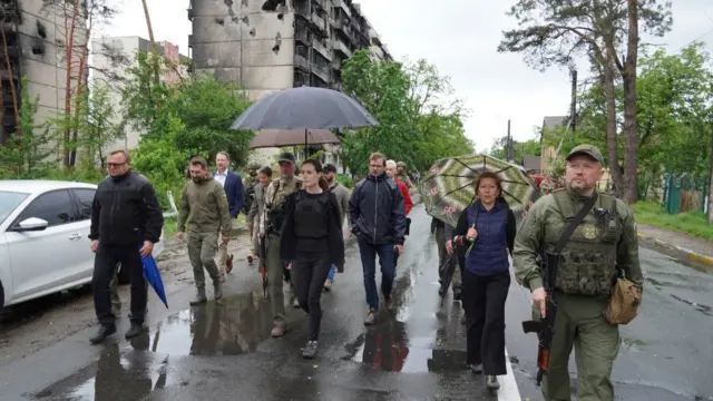 Finnish Prime Minister Sanna Marin walking with officials and armed soldiers