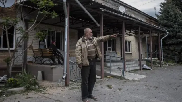 Man outside damaged hospital in Kharkiv area