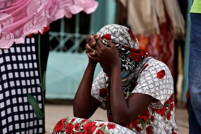 A mother of a ten-day-old baby grieves as she sits outside the hospital