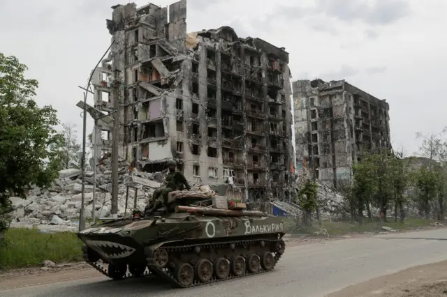 An armoured vehicle pictured in front of a damaged building