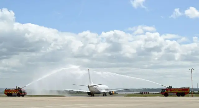 The Plane carrying the Liverpool squad given a water salute by two fire engines as it prepares to fly to Paris