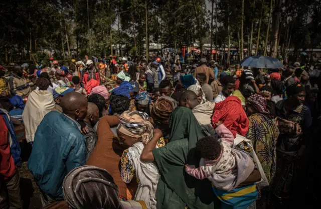 People who have fled the recent clashes between M23 rebels and Congolese soldiers, gather in Kanyarushinya north of Goma on 27 May 2022