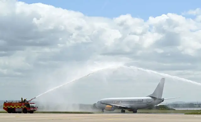 The Plane carrying the Liverpool squad given a water salute by two fire engines as it prepares to fly to Paris