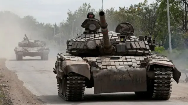 Tanks of pro-Russian troops drive along a street during Ukraine-Russia conflict in the town of Popasna in the Luhansk Region