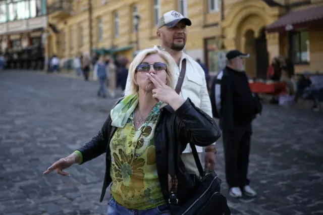 A woman blows a kiss in Kyiv