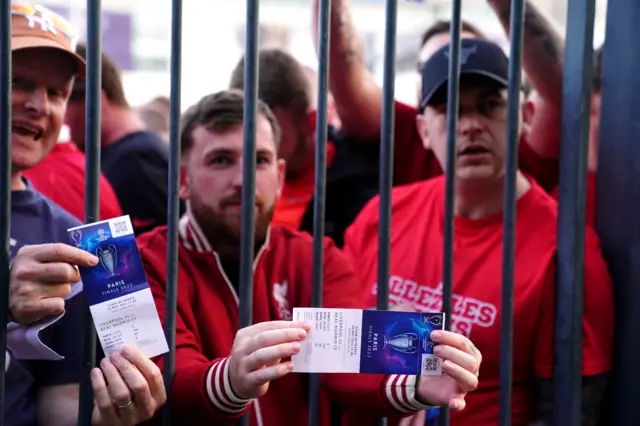 Liverpool fans show their tickets to photographers outside the Stade de France in Paris before the Champions League final