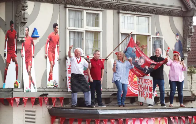 Liverpool fans on a small roof