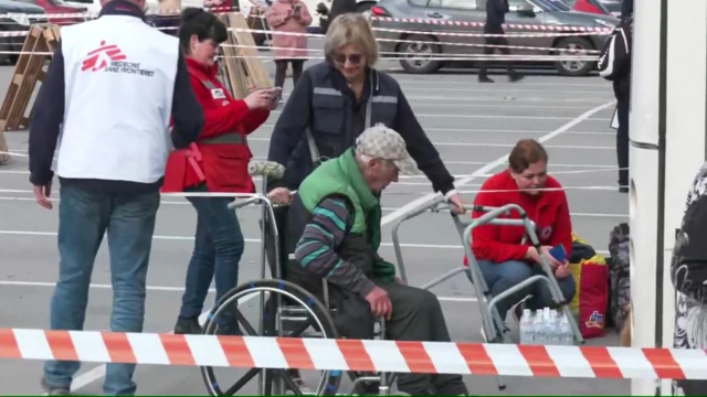 Refugee is helped into a wheelchair in Zaporizhzhia