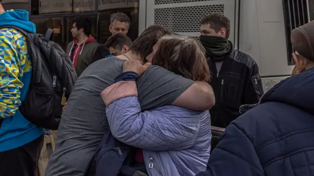 Two refugees hug after arriving on the bus to Zaporizhzhia