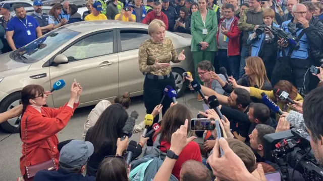 Journalists with microphones surround Ukraine's deputy PM