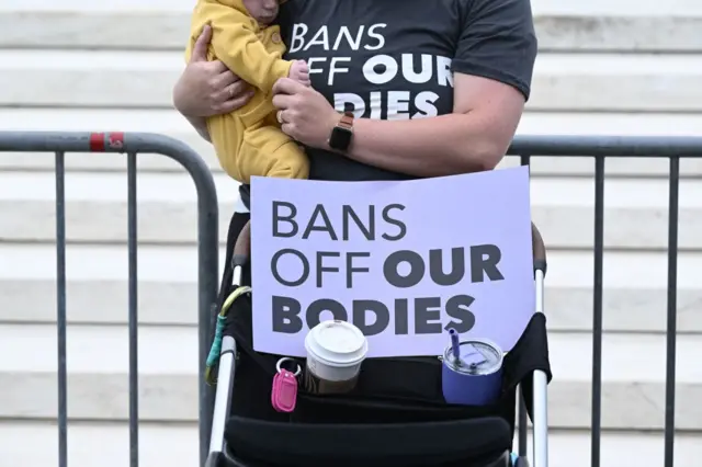 Sarah Goggans holds her daughter Lilith Centola in front of the US Supreme Court as demonstrators gather in Washington, DC, on May 3, 2022