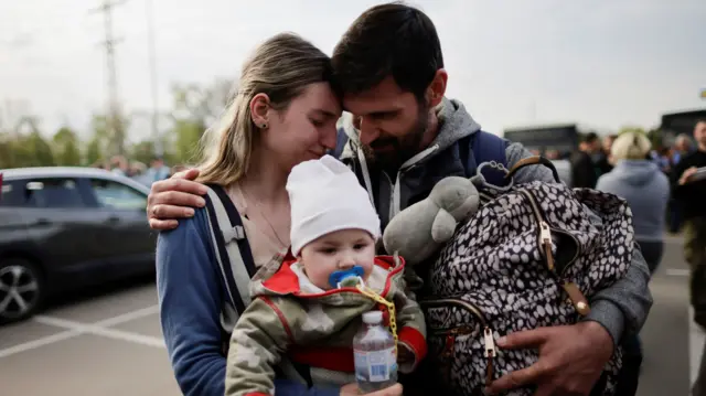 A family of Ukrainian evacuees from Mariupol embraces after arriving at a registration centre in Zaporizhzhia