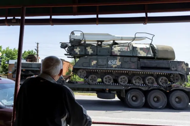 A local resident looks at a rocket launcher vehicle being transported, amid Russia"s invasion of Ukraine, near Kramatorsk, Donetsk region, Ukraine, May 30, 2022