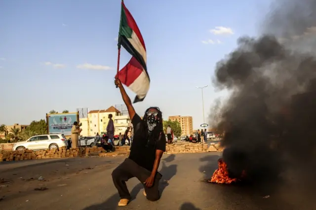 Previous page  Page Date: 05/30/2022 07:00:28 Sudanese protestor holds Sudan national flag during anti-coup protests in Khartoum, 30th October 2021