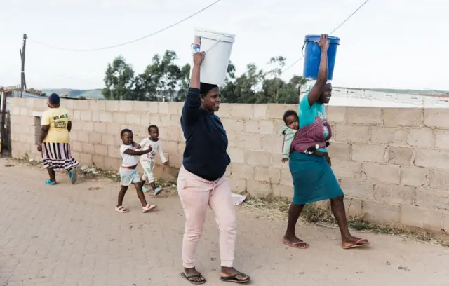 Women carrying buckets of water