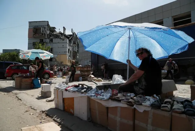 A street vendor sells shoes in the city of Mariupol