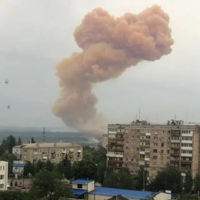 a large pink cloud over residential buildings in Severodonetsk