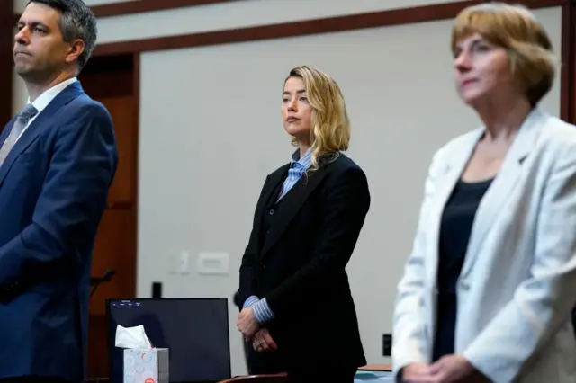 US actress Amber Heard (C) stands in the courtroom with her legal team at the Fairfax County Circuit Court, during a defamation case against her by ex-husband, US actor Johnny Depp, in Fairfax, Virginia