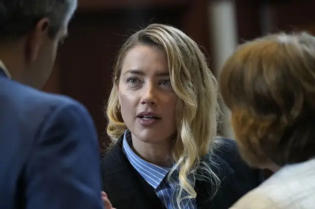 US actress Amber Heard speaks with her legal team during a lunch break at the Fairfax County Circuit Court amid a defamation case against her by ex-husband, US actor Johnny Depp, in Fairfax, Virginia, on May 4, 2022