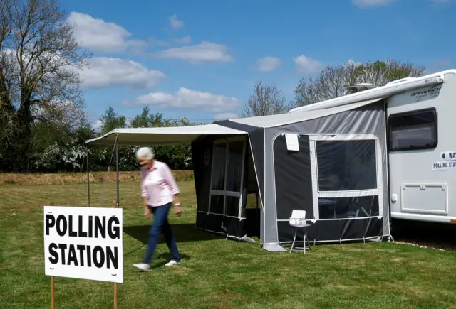 A woman leaves a motor home polling station in Chittering, near Cambridge