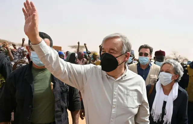 Antonio Guterres (C) waves as he visits an internally displaced persons (IDP) camp in Ouallam, Niger