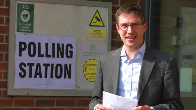 Green Party Co-Leader Adrian Ramsay in front of a polling station sign