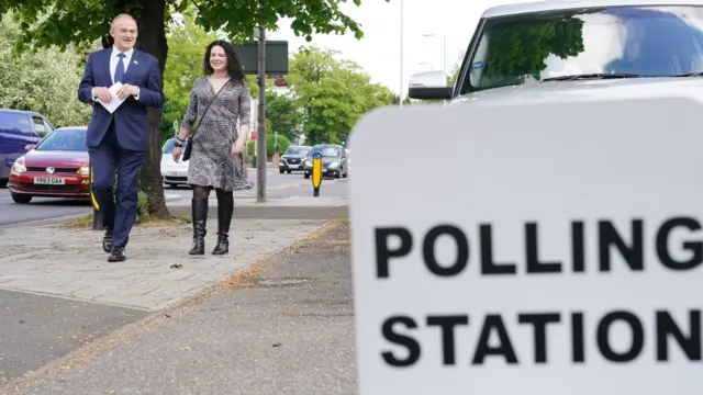 Sir Ed Davey walks outside a polling station