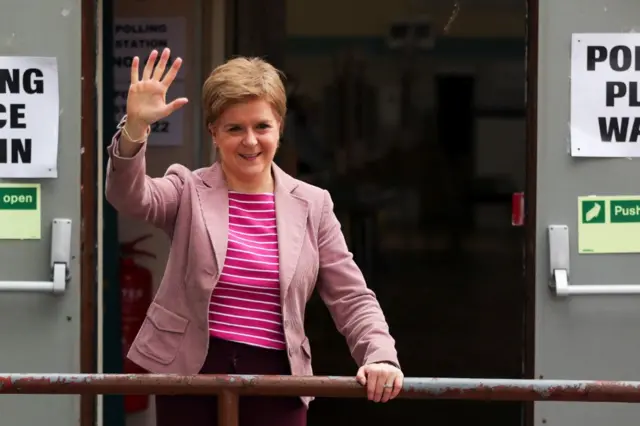 Nicola Sturgeon waves to reporters