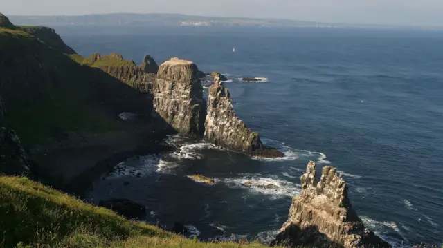 Rathlin island's coast, with water swelling around huge rock formations rising from the sea
