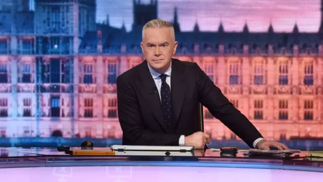 BBC presenter Huw Edwards behind a desk in a studio