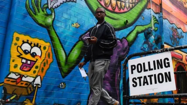 a man walks past a sign for a polling station