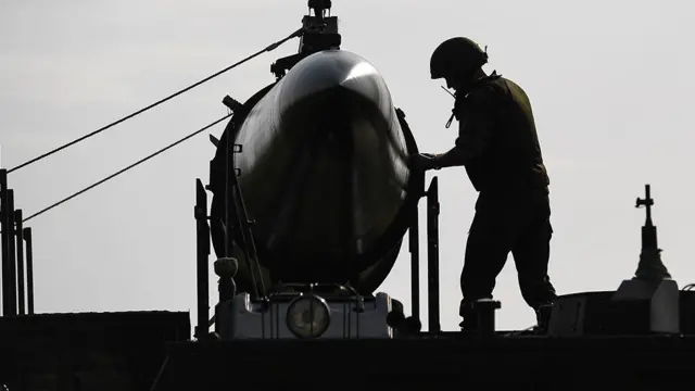 The silhouette of a soldier next to a missile