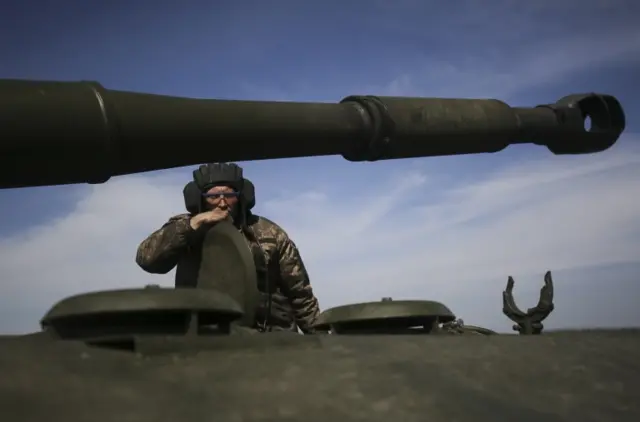 A Ukrainian serviceman looks on from a self-propelled howitzer, at an undisclosed area of Kharkiv, Ukraine