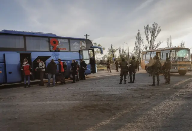 Russian servicemen control the boarding of a bus by civilians evacuated from Azovstal in Mariupol on Friday 6 May