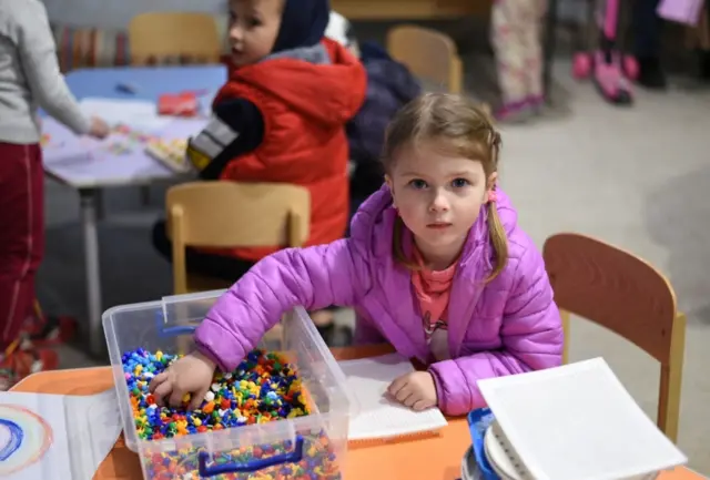 A girl plays during a children"s party in the basement of a kindergarten as air raid sirens sound, in Kamianske, Ukraine on 6 May