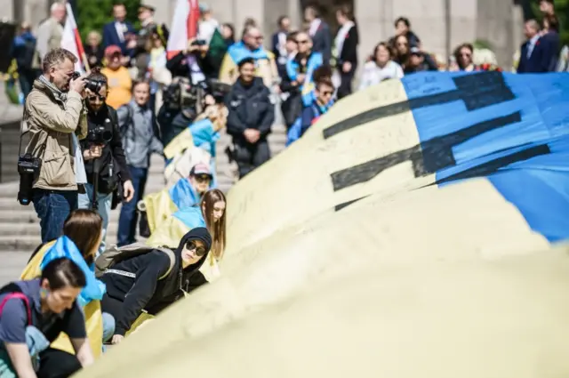 Activists unfold Ukrainian flag reading "they are us" at VE Day celebrations in Berlin, Germany