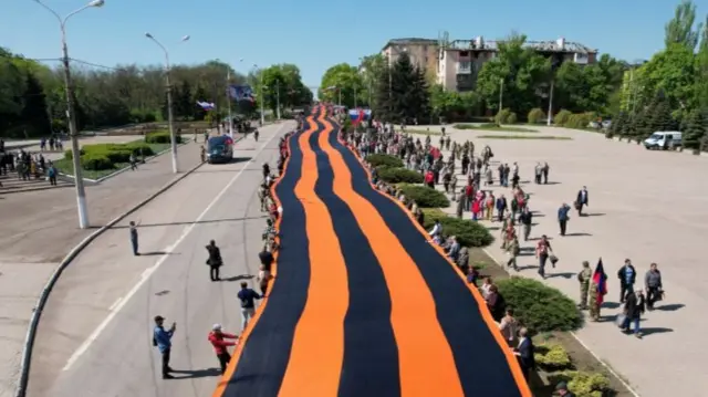 St George's Ribbon banner carried through streets of Mariupol