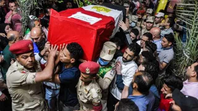 Mourners carry the casket of Egyptian conscript Ahmed Mohamed Ahmed Ali, one of 11 soldiers killed in the attack