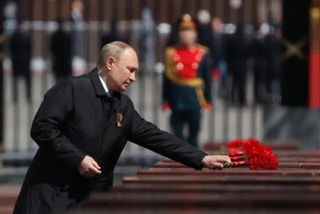 Putin places flowers on a memorial to veterans