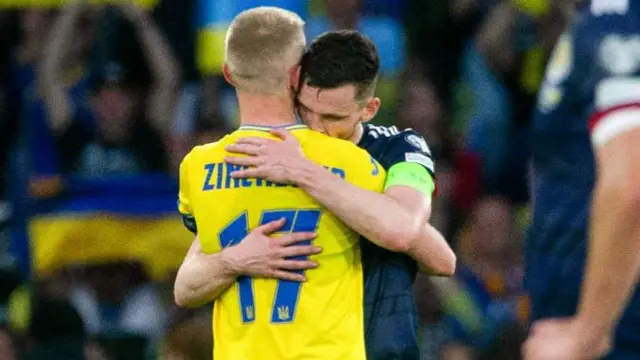 Captains Zinchenko and Robertson share an embrace at full-time