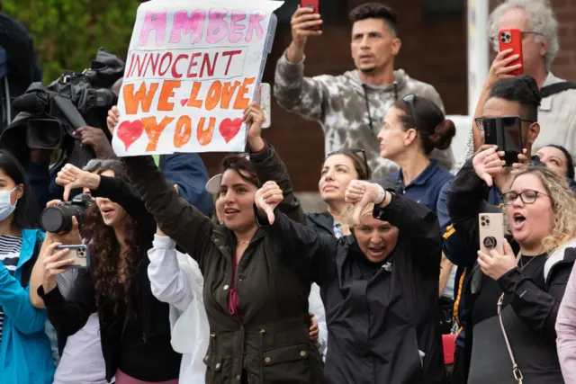 An Amber Heard fan holds a sign saying Amber innocent we love you