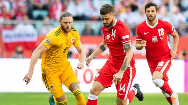 Mateusz Klich of Poland goes past Wales' Wes Burns