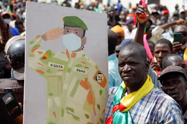 A supporter of Malian Interim President Assimi Goita holds up his image during a pro-junta and pro-Russia rally in Bamako on May 13, 2022.